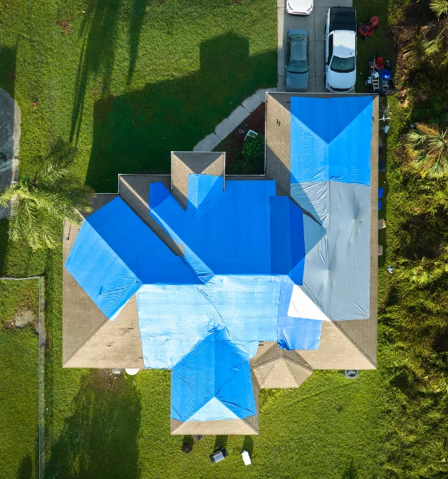 Aerial view of roof covered with blue tarp