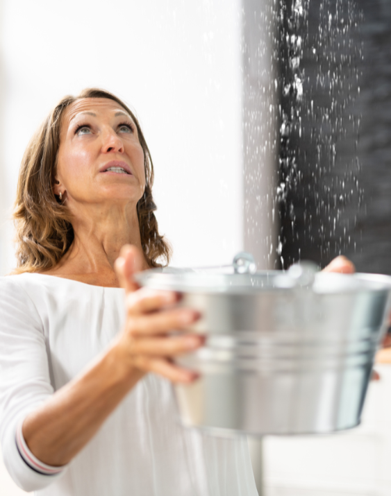 woman holding buckets to control leaking roof