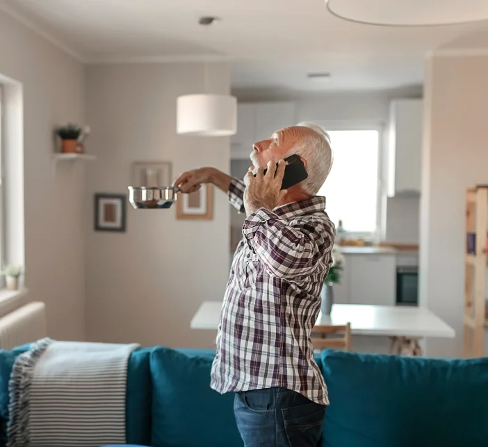 man holding plate under leaking roof