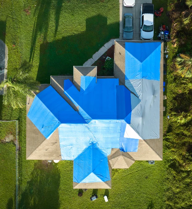 Aerial view of roof covered with blue tarp